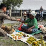 Senyum Mama-Mama Papua Saat Bripda. Rafly Personel Ops Damai Cartenz-2025 Ulurkan Payung